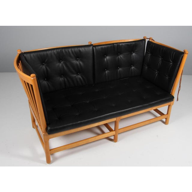 Børge Mogensen two-seat sofa in lacquered beech and new upholstered cushions of black pure full grain aniline leather....