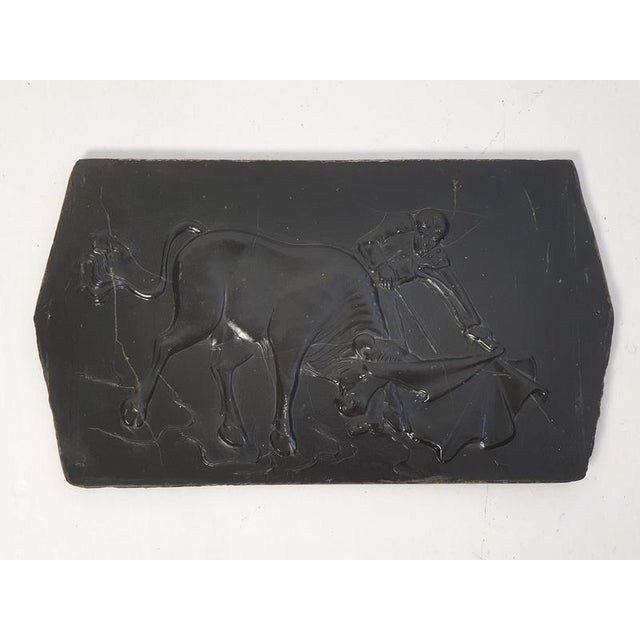 A wall plaque in slate depicting a bullfighter and bull. Produced sometime during the 1970's. In good condition with some...
