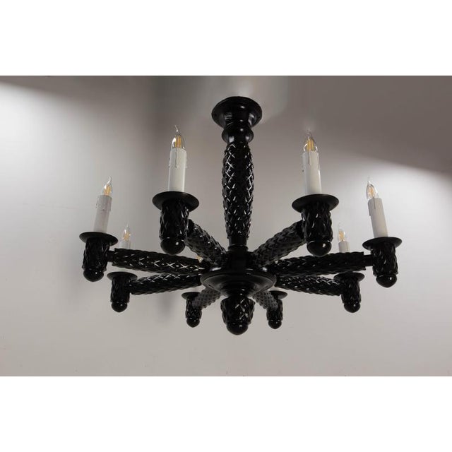 Eight-light french chandelier in black lacquered in carved wood, circa 1960. An imposing french chandelier from the 1940s,...