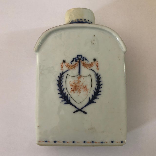 A Chinese export porcelain armorial tea caddy without lid. The family crest dominates both sides and is accented with a...