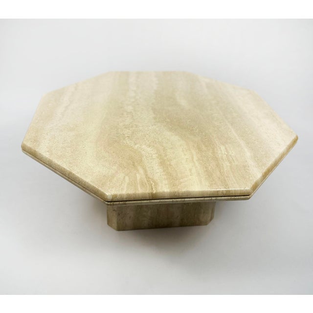 Elegant vintage coffee table from the 1970s, in solid vanilla-colored travertine. The sculptural design features a...