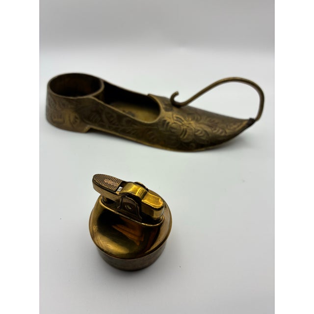 This sculptural vintage table lighter was procured from an estate and crafted in engraved brass with an elongated, organic...