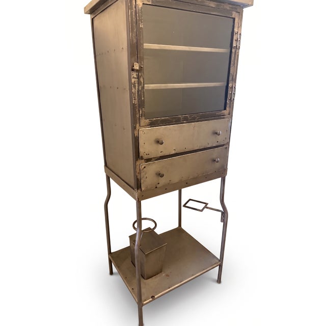 Vintage silver metal dental / apothecary cabinet. Enclosed and display storage: Three upper shelves with glass door and...
