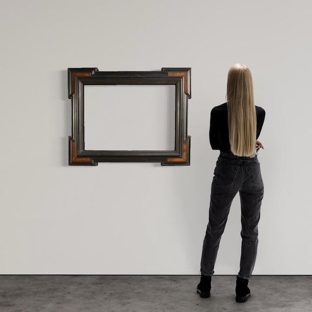 Mid-20th-century Italian frame. Guilloche-style carved wood furniture, ebonized with walnut veneer decoration at the four...