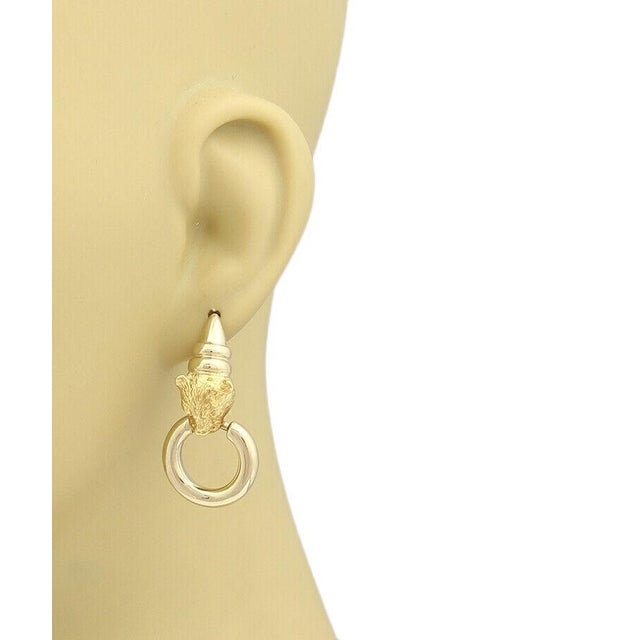 The Citra 18k Yellow Gold Panther Door Knocker Dangle Earrings are a luxurious and stylish accessory that features a...