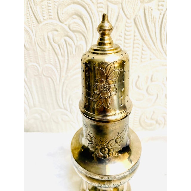 The most beautiful sugar shaker otherwise known as a muffineer ever. It has a blown out floral design and I believe it is...