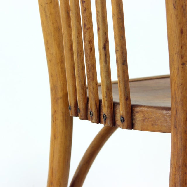 This elegant vintage chair, crafted by the renowned Thonet company, is a distinguished example of bentwood design....