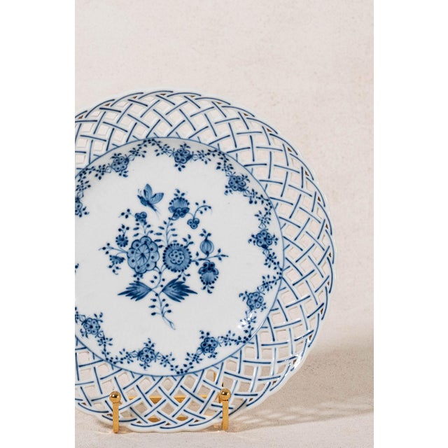 Pair of antique German reticulated plates featuring pierced borders, hand-painted blue and white decoration, and scalloped...