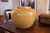 A rounded ceramic pot or vessel finished in a warm mustard glaze, decorated throughout with finely incised floral and...
