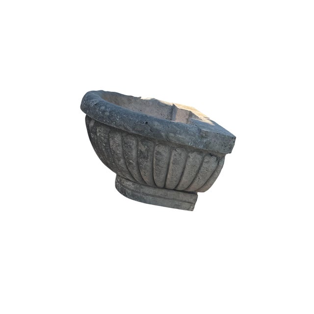 A striking solid natural limestone basin featuring deeply carved gadrooned fluting, a substantial rounded rim, and a...
