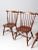 A classic set of four Windsor dining chairs dating to the 1950s, featuring the timeless fan-back design with slender...