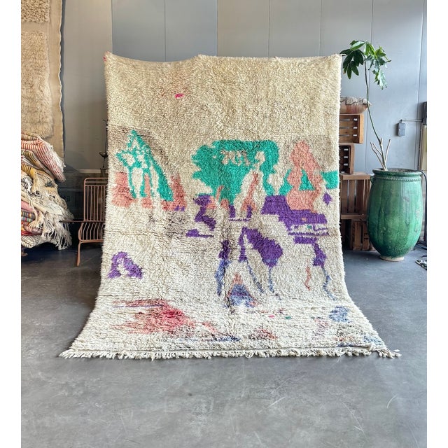 This Boujad rug was hand-knotted by Berber artisans in the Middle Atlas region of Morocco. The ivory wool ground is...