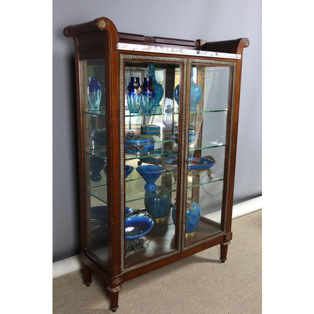 Mahogany display case opening with two doors from the end of the 19th century. This display case has a glass bottom, the...