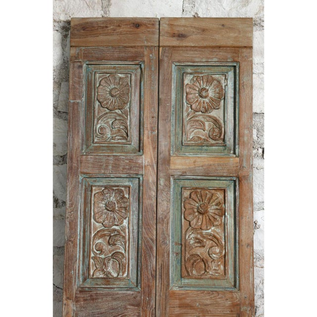 Exquisitely hand-carved with floral motifs, these antique French double doors offer a rare blend of rustic elegance and...