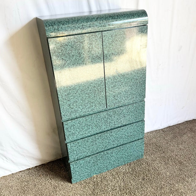 This striking postmodern armoire showcases a bold faux–teal granite laminate wrapped in dramatic waterfall curves,...