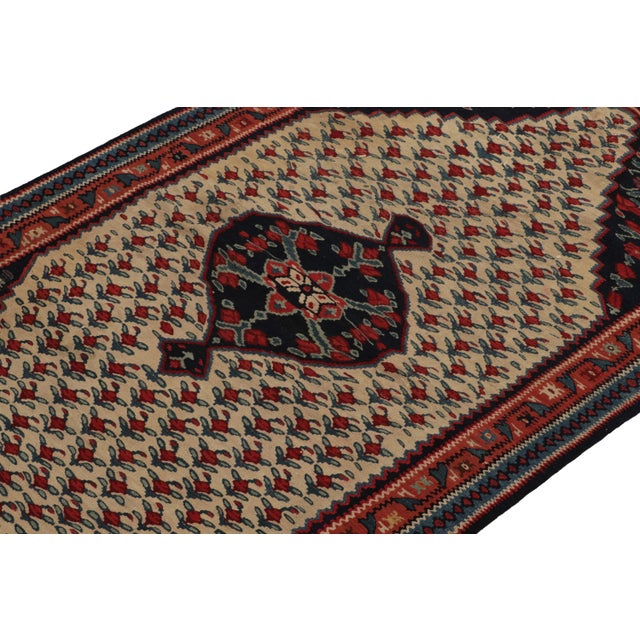 Handwoven in wool, a 3x5 antique Senneh Kilim rug originating circa 1930-1940. This beautiful piece showcases a brilliant...