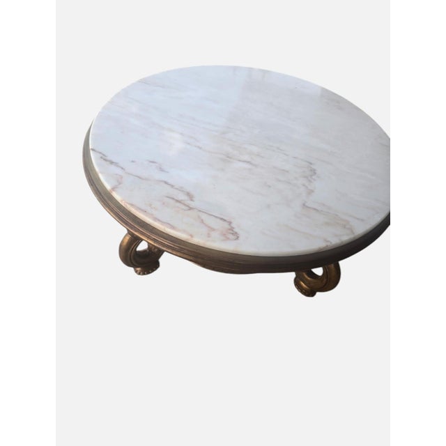 An elegant vintage Portuguese coffee table featuring a substantial round Rosa Aurora marble top resting on an ornately...