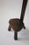 A sculptural three-legged side chair in stained and carved oak. The tall, narrow form draws attention to the texture of...