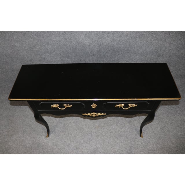 This refined French Louis XV ebonized console table is a distinguished example of classic French craftsmanship, produced...