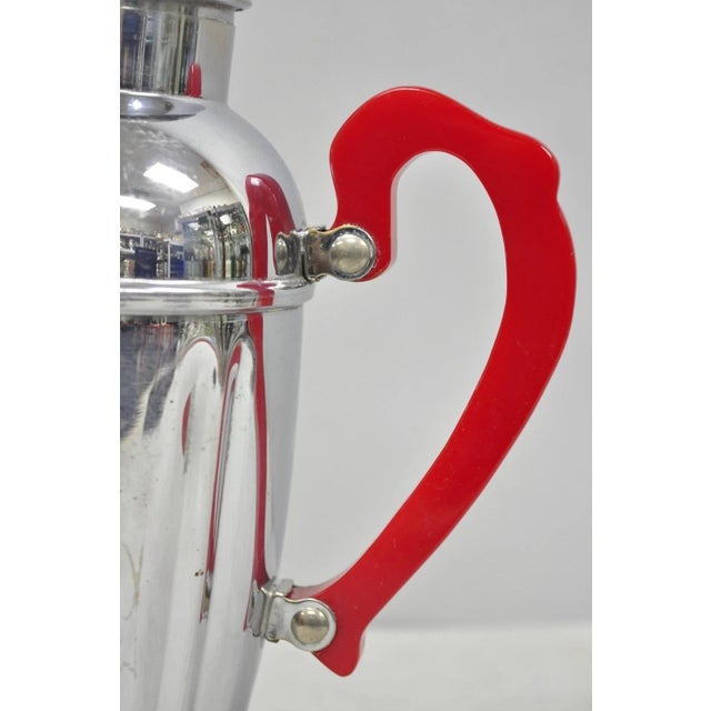 Vintage Art Deco Chrome Cocktail Martini Shaker with Red Bakelite Handle by Chromium. Circa Mid 20th Century....