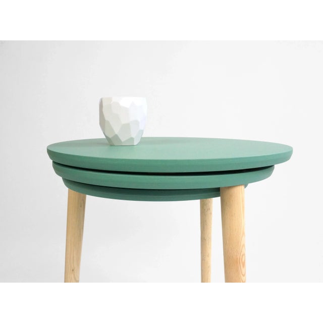 A compact side table by Studio Lorier, which can slide out to create almost triple the surface area. The three wooden...