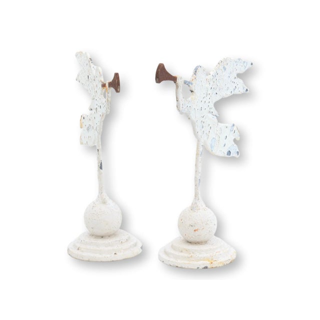 Pair of metal angel ornaments on a base. Handcrafted in England from reclaimed antique materials. White powder-coated...