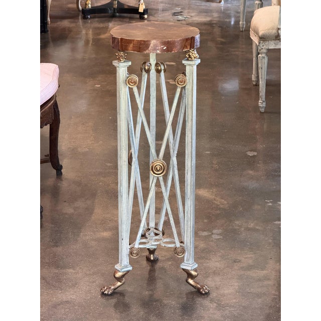 Three square tapered uprights with gilt paw feet and small gilt mask mounts, joined by crossed rods with gilt rosettes,...