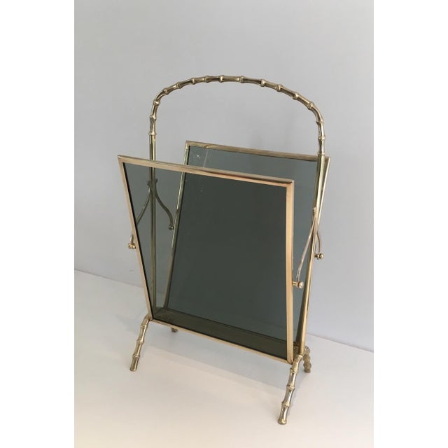 This faux bamboo magazine rack is made of bronze with blueish glass panels on each side. It is a French work from Maison...