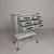 This unit features six drawers with black Bakelite handles. The top and bottom surfaces are made of white opaline glass....