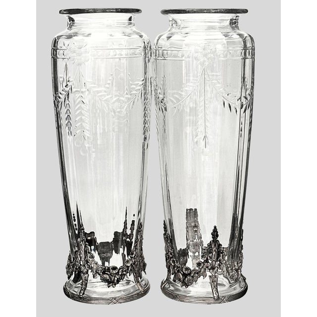 Pair of elegant French crystal vases with finely cast silverplate mounts, featuring richly detailed floral garland bases...