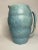 This ceramic 'made in England'' blue pitcher by Arthur Wood has a unique rippled design which lends to a modern,...