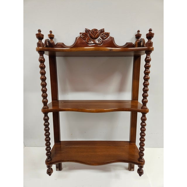 This stunning cherry three-tiered wall-mount shelf unit is by Carl Forslund and has turned supports, fretwork and finials....