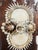 A striking handcrafted shell art wall plaque featuring an elaborate arrangement of natural seashells mounted on an antique...