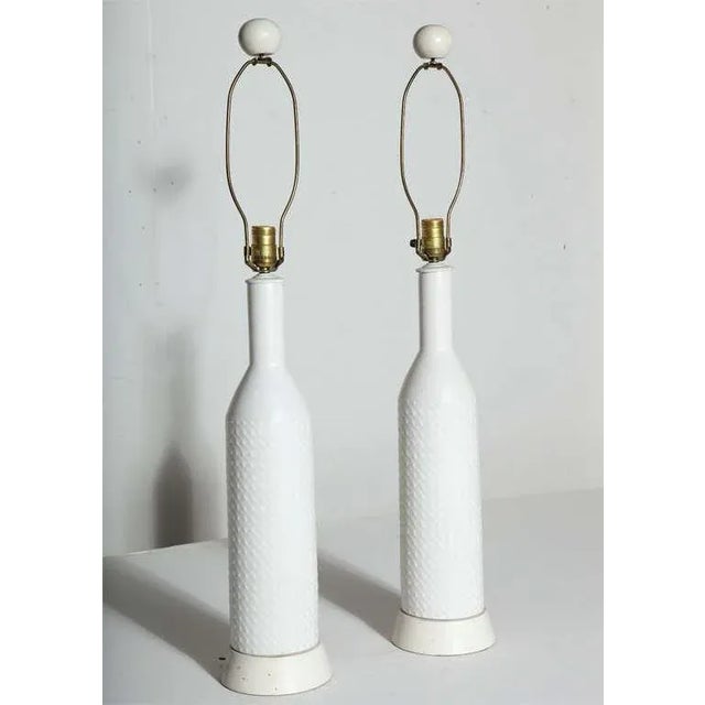 Tall Pair of A-H KAG Switzerland Off-White textured Ceramic Lamps. Featuring a slim bottle form with uniform flowing dot...