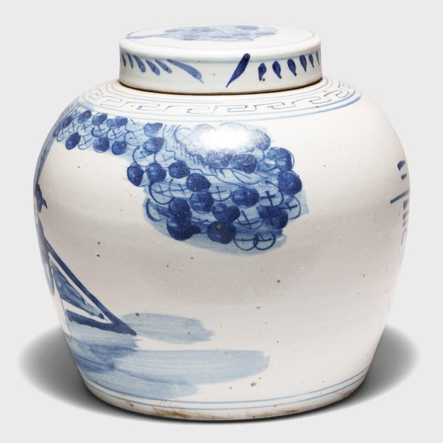 Loosely brushed with cobalt blue underglaze, this blue-and-white ginger jar is painted with a scene of scholars and young...