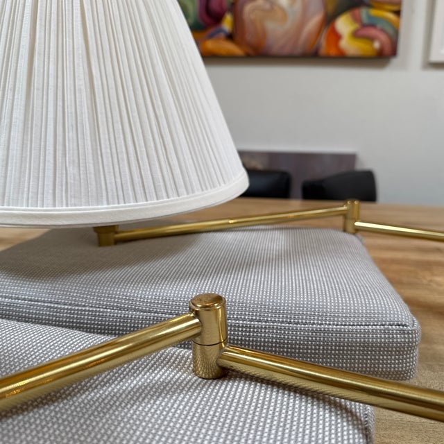 Design Plus Gallery presents a Pair of Reticulating Brass Arm Wall Sconces. The duo have pleated white shades with long...