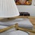 Design Plus Gallery presents a Pair of Reticulating Brass Arm Wall Sconces. The duo have pleated white shades with long...