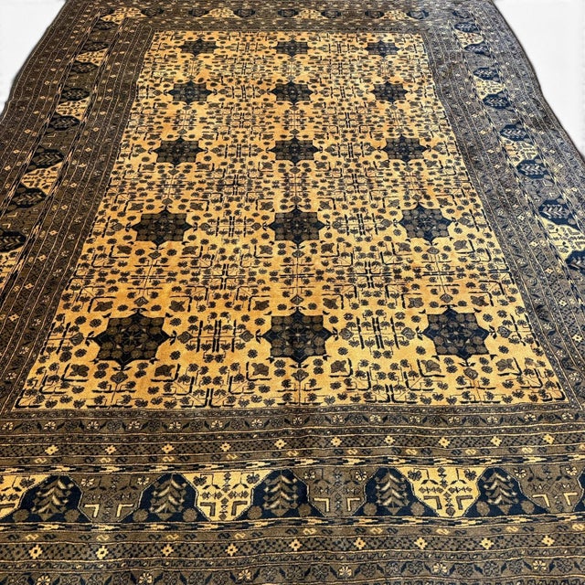 This vintage Afghan rug, approximately 40 years old, presents a beautifully balanced allover design centered around a...