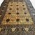 This vintage Afghan rug, approximately 40 years old, presents a beautifully balanced allover design centered around a...