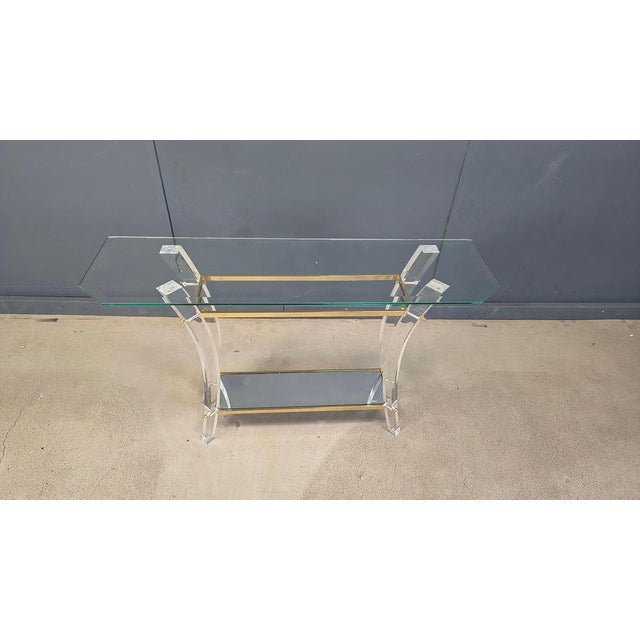 Vintage two tier console table with a brass and acrylic glass frame and glass shelves. Attributed to Charles Hollis Jones....