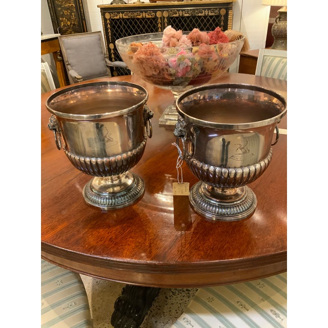 Pair of silver-plated wine coolers with flared rims, lion-mask ring handles, and reeded lower bodies. Each sits on a...