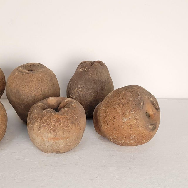 A group of seven large terracotta unglazed apples and pears, circa 1900. (Two apples, measuring 5.5" h x 6" w x 6.5" d,...