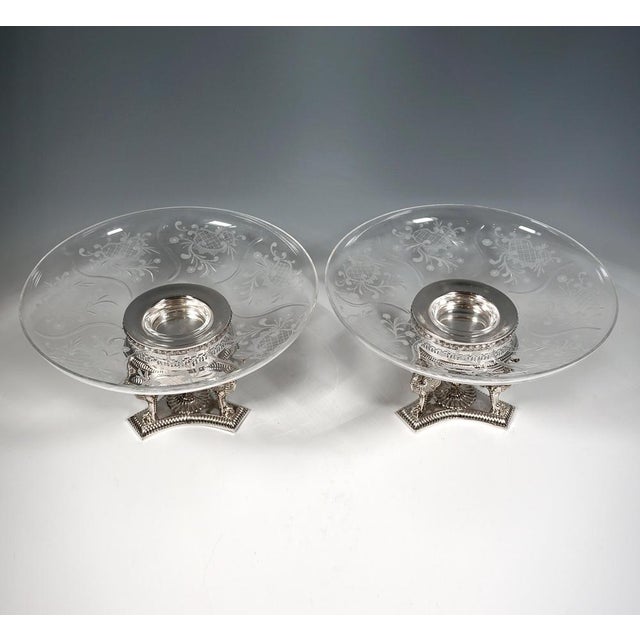 Two elegant silver centerpieces on a three-pass base with delicate embossed decoration and three winged lion figures...