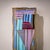 Wall light featuring a rectangular glass shade infused with blue-green and rose-toned inclusions. The clear glass is...