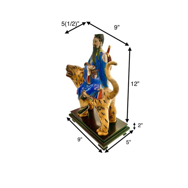 The product is a vintage Japanese porcelain statue of a tiger, presented on a wooden base, adding an element of...
