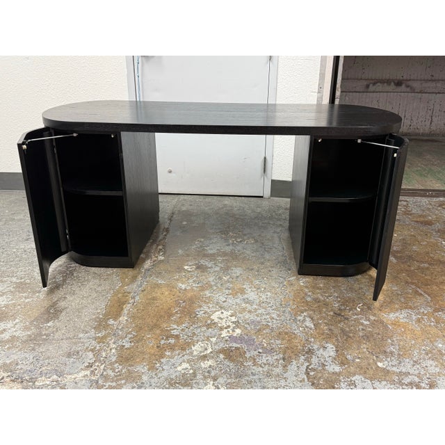 Design Plus Gallery presents the Reid Oval Black Wood Storage Desk by Mermelada Estudio for CB2. This desk has an oval...