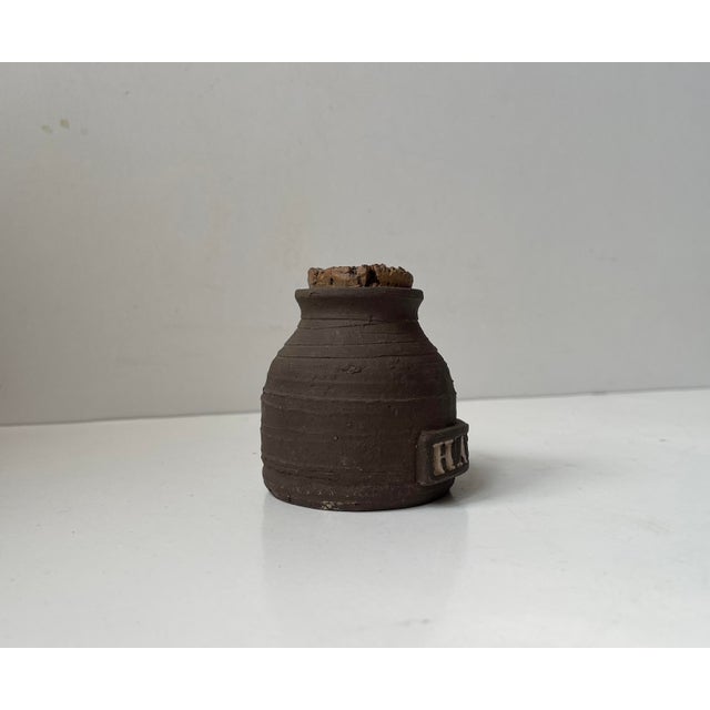 Aa very rare small canister or jar intended for storing Hash. Executed in brown ceramic with text in white salt glaze....