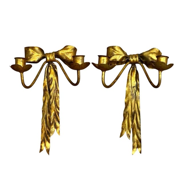 A charming pair of vintage tole wall sconce/candle holders. Each features a handmade bow form base adorned with trailing...