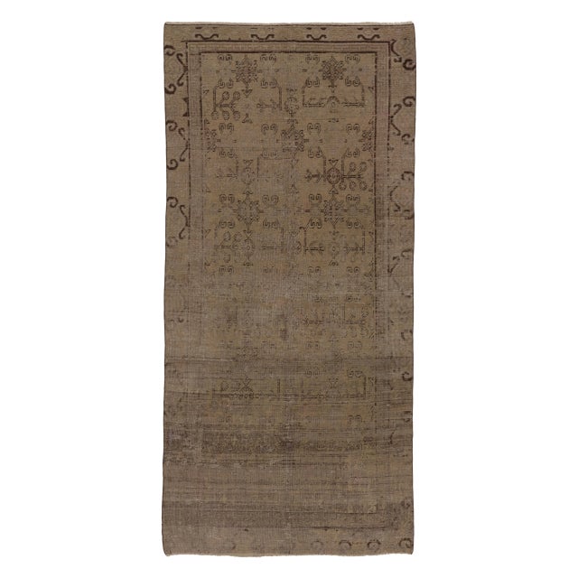 Hand-knotted in wool circa 1910-1919, this 5x11 antique East Turkestan Khotan runner is a regal addition to Rug & Kilim's...