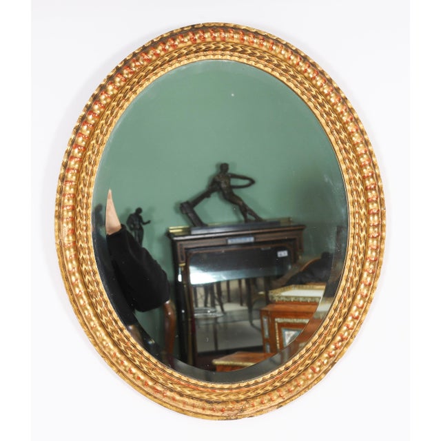 This is a superb pair of antique French giltwood mirrors, circa 1870 in date. The oval mirrors plates are set within a...